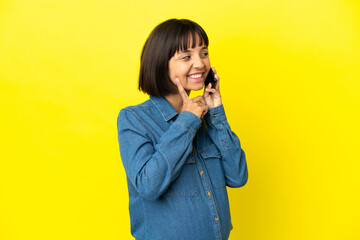 Pregnant woman using mobile phone isolated on yellow background thinking an idea while looking up