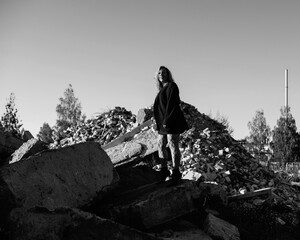 Portrait of a young beautiful blonde girl in a black jacket in nature. Black and white photo.