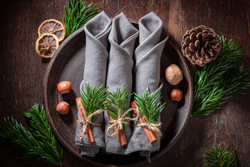 Christmas table setting decorated with cinnamon and spruce