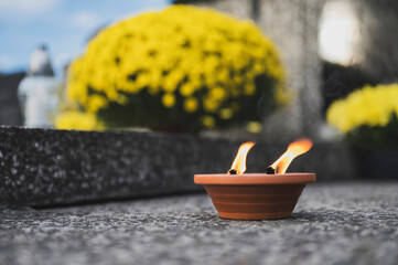 Lit Candle on a Grave Surrounded by Autumn Leaves During All Saints' Day in Poland