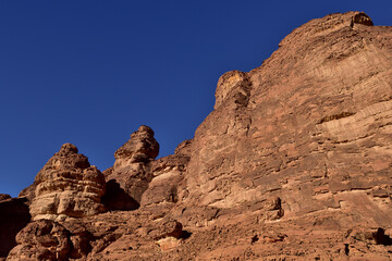 A series of red stone monoliths against a clear blue skry in Al Ula Saudi Arabia