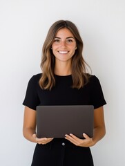 Fototapeta premium Happy young woman with a laptop in her arms standing isolated on white background, smiling female businesswoman with computer device posing for portrait.