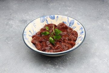 Cut raw beef liver with onions, spices, chili peppers and dill on wooden table, flat lay