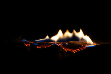 burning paper, glowing edge of paper on a black background.