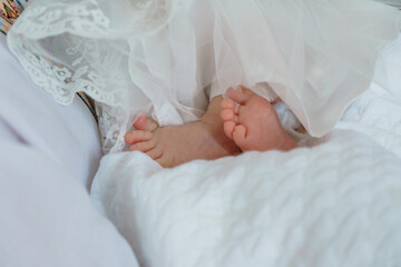 Sweet Innocence: A Close-Up of Baby Feet Peeking from Delicate White Fabrics
