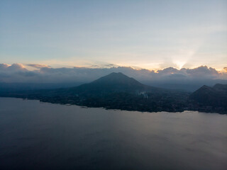 A serene view of a mountain at dusk with a calm body of water.