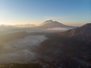 A breathtaking sunrise over a mountainous landscape enveloped in mist.