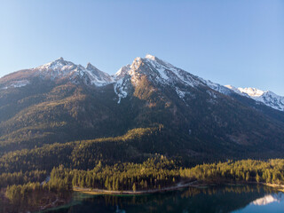 Stunning mountain range with snowy peaks and a serene lake below.
