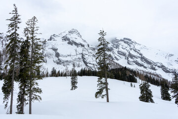 Snow-covered mountains stand majestically under a cloudy sky.