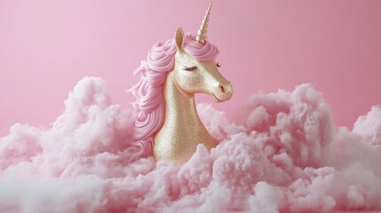 A golden unicorn head with pink mane emerges from fluffy pink clouds against a pink background.