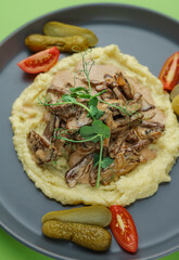 Mashed potatoes with mushrooms, mushroom sauce and gherkins