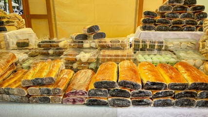 A display of diverse traditional Eastern European pastries and breads at a market, evoking holiday...