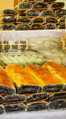 Assorted traditional Filipino breads and rice cakes neatly stacked on display at a local market, highlighting cultural diversity and culinary tradition