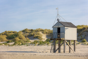 A wooden shelter on high stilts that stands on the North Sea beach (De Drenkelingenhuisje) The...
