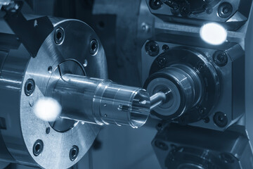 The multi-tasking CNC lathe machine milling the metal tube parts by milling spindle in the light...