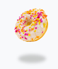 Flying donut made of white chocolate and multi-colored sprinkles with isolated on white background