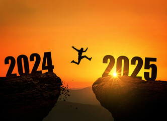 Man jumping on cliff 2025 over the precipice at amazing sunset. New Year's concept. Symbol of starting and welcome happy new year 2025. People enters the year 2025, creative idea