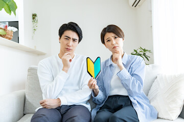 初心者マークを持ち考えるカップル