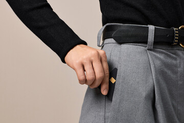 female hand putting black premium credit bank card in pants pocket. Money finance