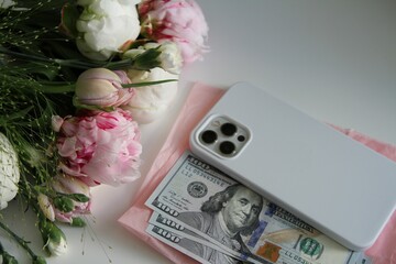 Bouquet of fresh flowers, phone and money. Horizontal arrangement