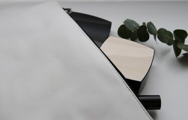 White cosmetic bag with cosmetic products and eucalyptus leaves