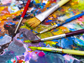 Tangerang, Indonesia - October 12, 2024: Paint brush for painting. With colorful oil artist paint palette board background. Oil paint brush.