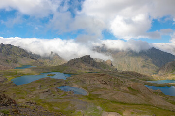 Landscape of the lakes and mountain ranges with rolling clouds over the peaks