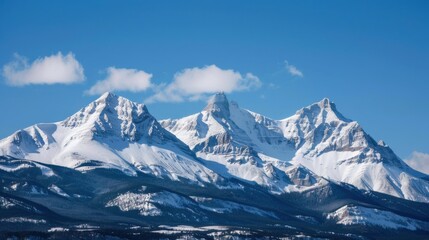 Obraz premium A captivating view of the Rocky Mountains in winter with snow-covered peaks and a clear, crisp sky, mountainous setting with wintry beauty