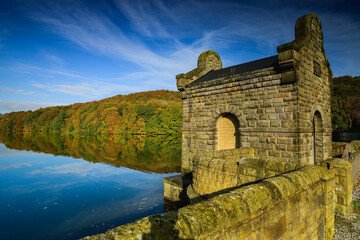 Building on the shore of a lake, autumn in the background