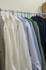 Minimal rack male clothes on hangers. In closet, dressing room for wardrobe at bachelor's apartment interior. Man outfits store.