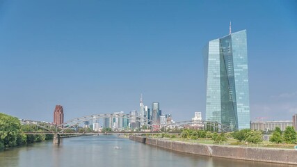 Hyperlapse of Frankfurt skyline featuring the modern ECB headquarters skyscraper with reflective steel-glass facade, train arch bridge and clouds in the blue sky timelapse. Frankfurt am Main, Germany