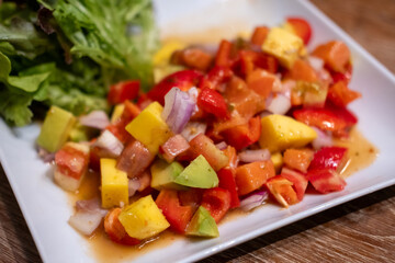 Spicy Salmon sashimi with mango salad served on plate