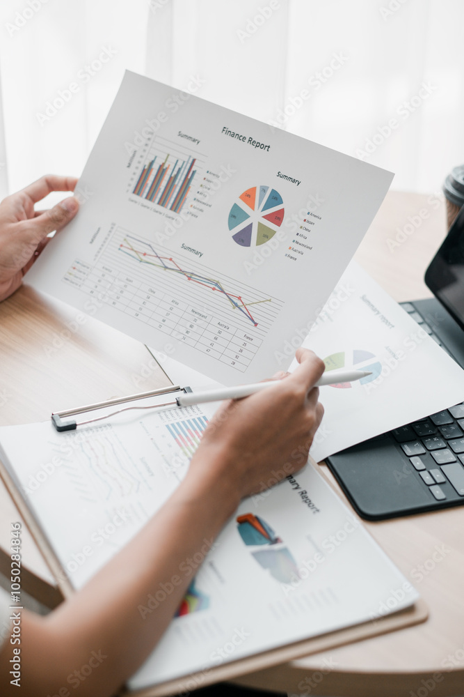 Poster close-up of hands holding financial reports with graphs and charts, showcasing data analysis in a pr