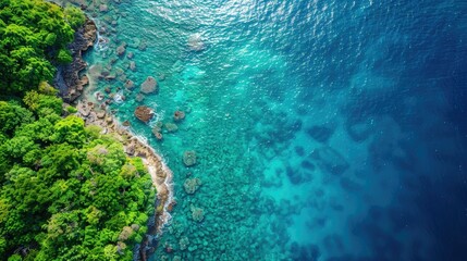 Aerial view of a coastal landscape with clear blue water and lush green vegetation.