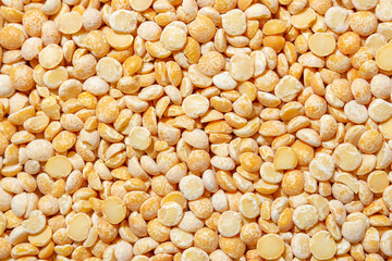 Uncooked Polished Split Peas Background. A Culinary Canvas of Dry Yellow Peas, Creating a Lively and Textured Background for Gourmet Cooking. Scattered Raw Polished Peas. Healthy Eating Ingredients
