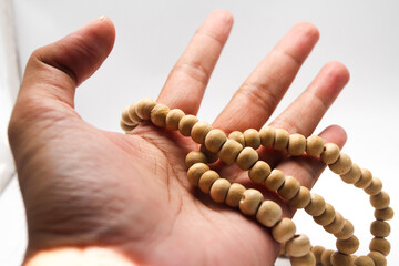 Male hand asian holding muslim beads rosery or tasbih for pray with isolated background.