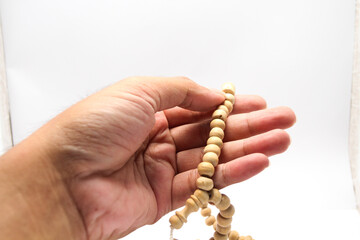 Fototapeta premium Male hand asian holding muslim beads rosery or tasbih for pray with isolated background.