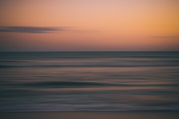 Obraz premium Dreamy seascape with motion blur and fading sunset colors.
