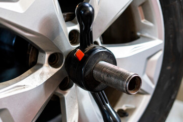 Mechanic works in tire repair shop. Car service mechanic puts wheel on car rim using special...