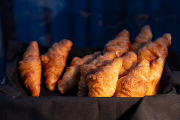 A basket of croissants is displayed on a black background