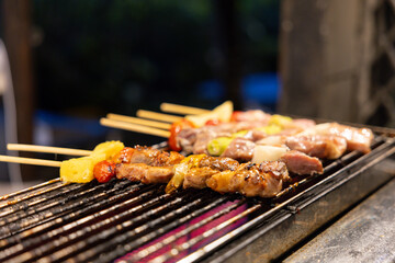 A electric grill with a variety of meats and vegetables on it.