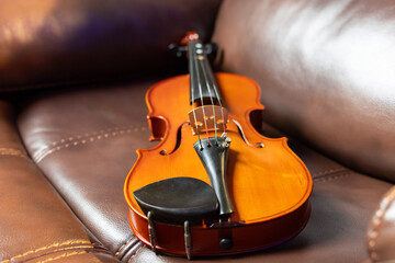 Obraz premium A violin is sitting on a brown couch