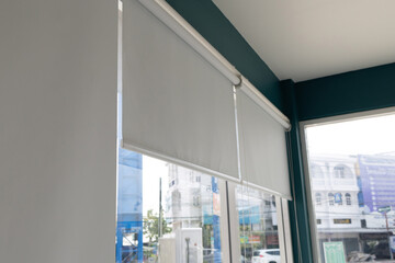 A window with a white curtain and a view of a city