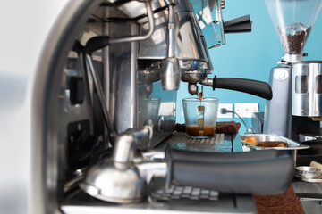 A coffee machine with a glass of coffee in it