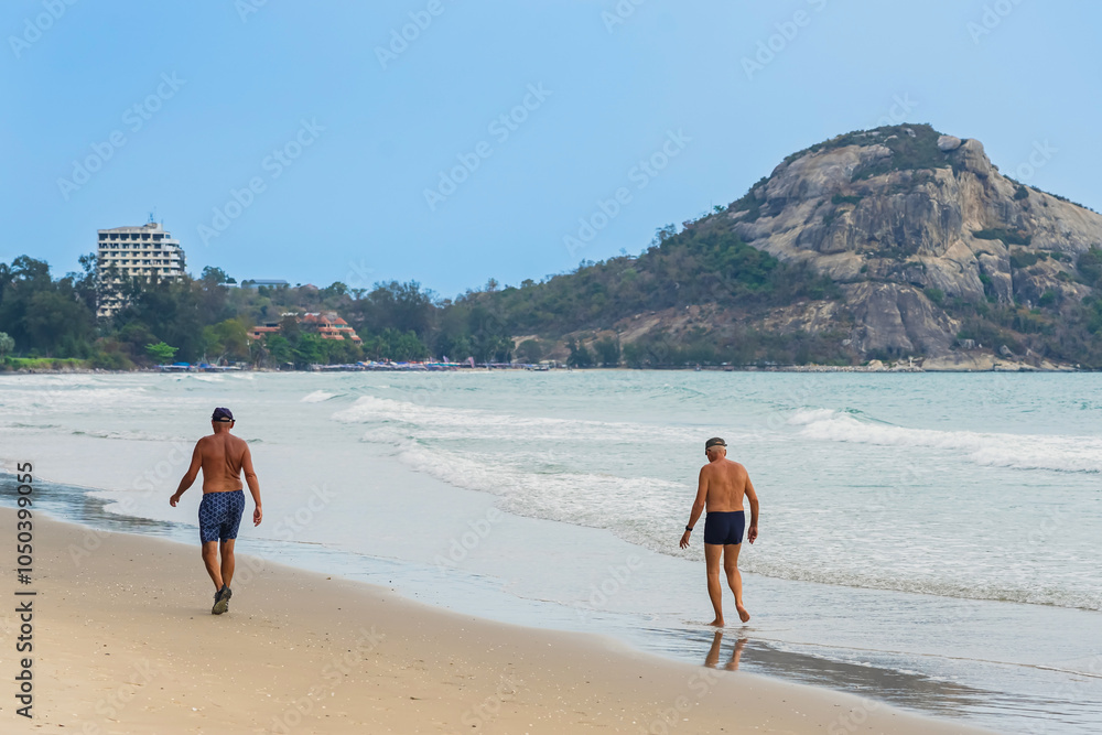 Wall mural back view of senior friends enjoying the beach in the summertime. cheerful group of friends or famil