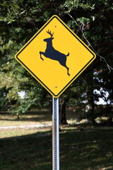 A bright yellow and black deer crossing sign.