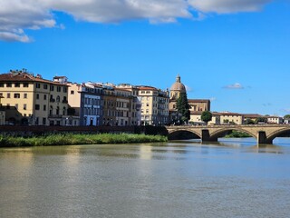Fototapeta premium Florence, Italy - October 5, 2024: Discovering the city of Florence in autumn days. Frome the Duomo to Ponte Vecchio, old architecture covering the city. Beautiful sky reflected over Arno river.