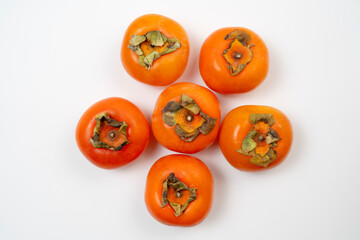 Persimmons are sweet, orange fruits commonly enjoyed in autumn