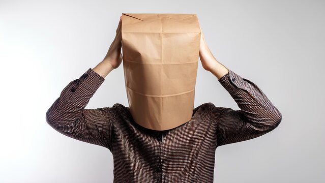 Concept: unknown person, faceless image. Man with a paper bag on his head, white background.
