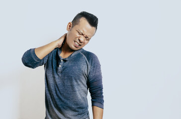 Tired asian man touching neck with pain expression isolated on white background.